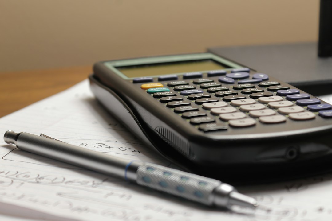 A calculator and pen on an accounting workpaper